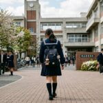 高校正門前を歩く制服の生徒